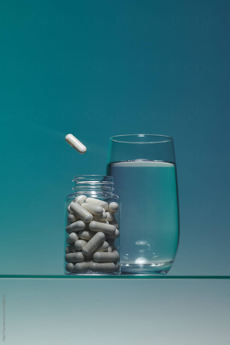 White pillare flying out of the glass jar near a glass of water