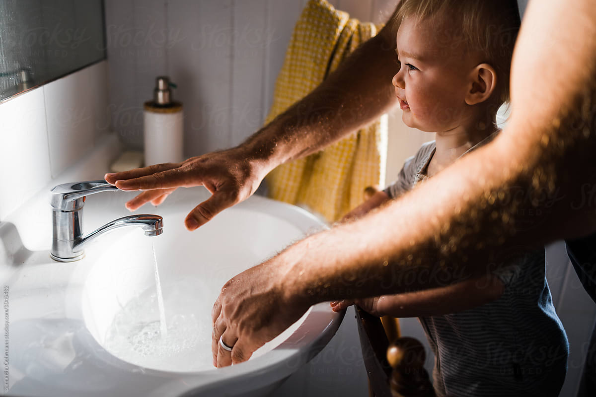 Father turns off tap while washing Childs hands