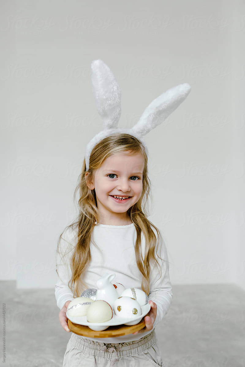 Cheerful girl with Easter eggs and in bunny ears