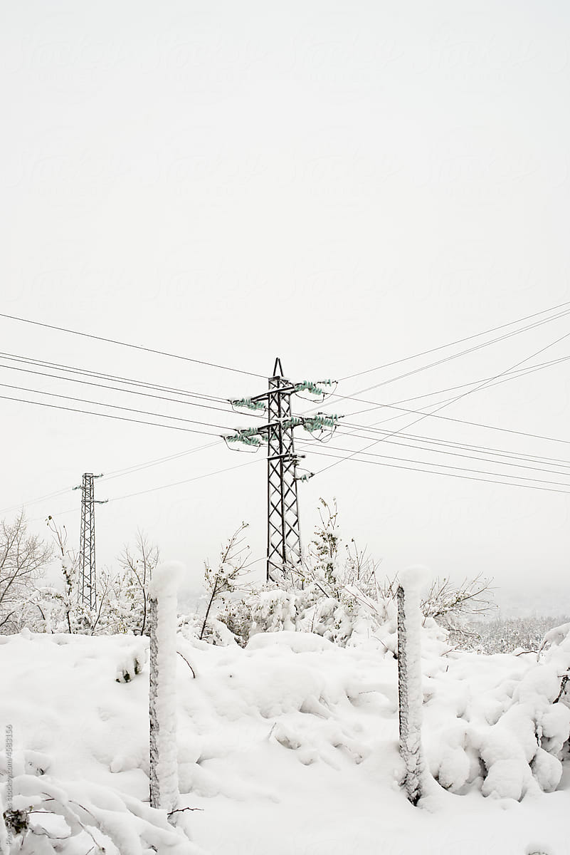 Power lines with snow in extreme weather. Winter power outage.