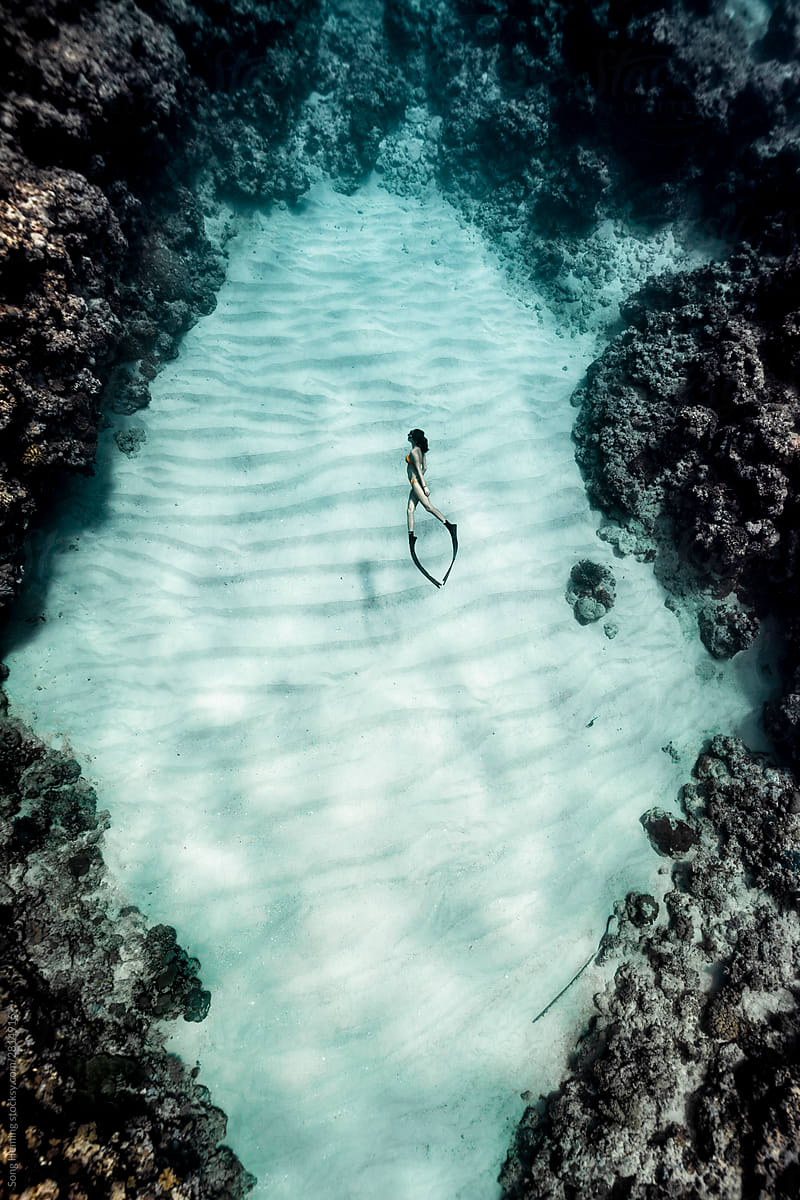 A female free diving on Manta ray shape sand