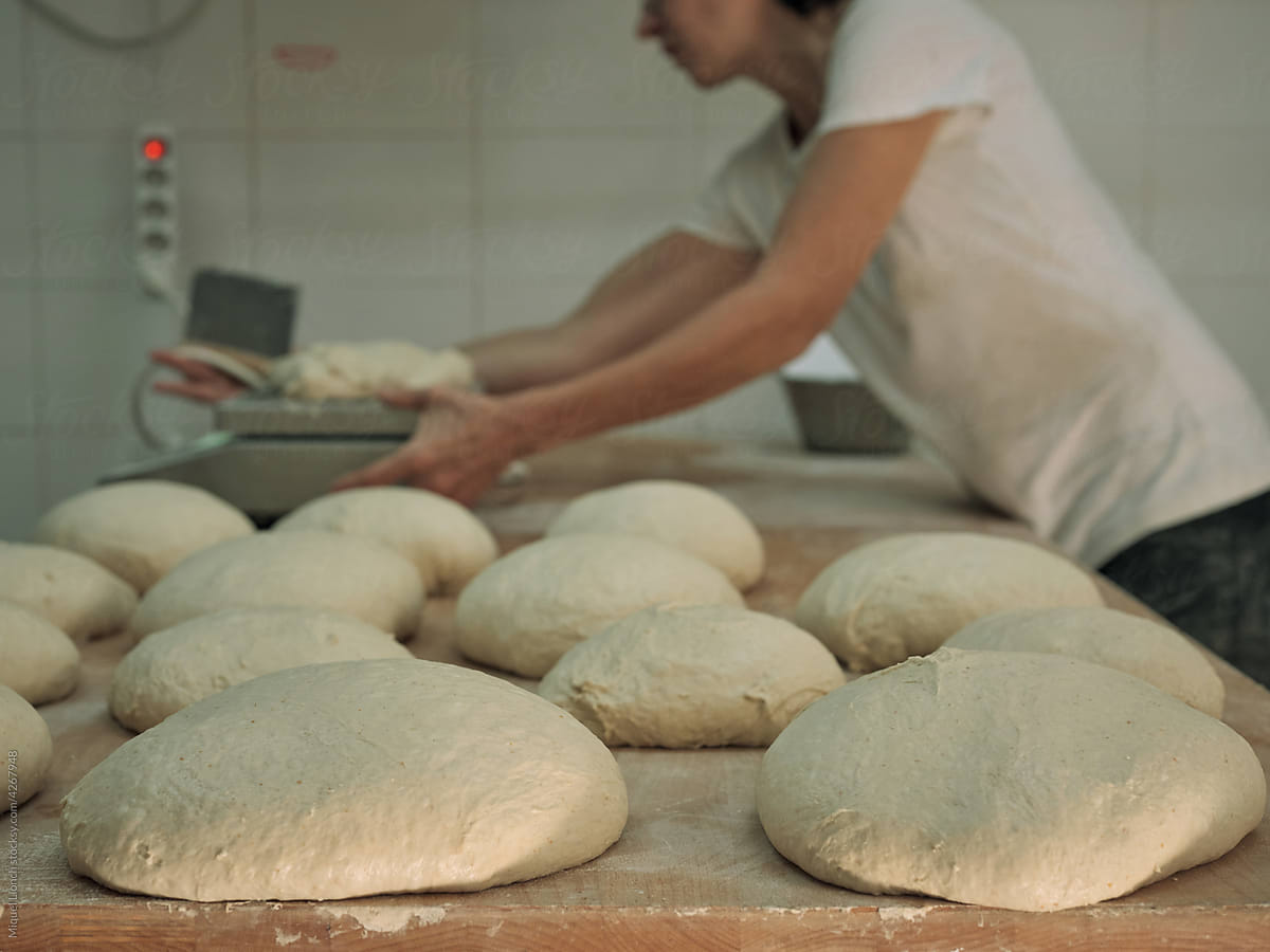 Artisan baker at work with bread dough preparation