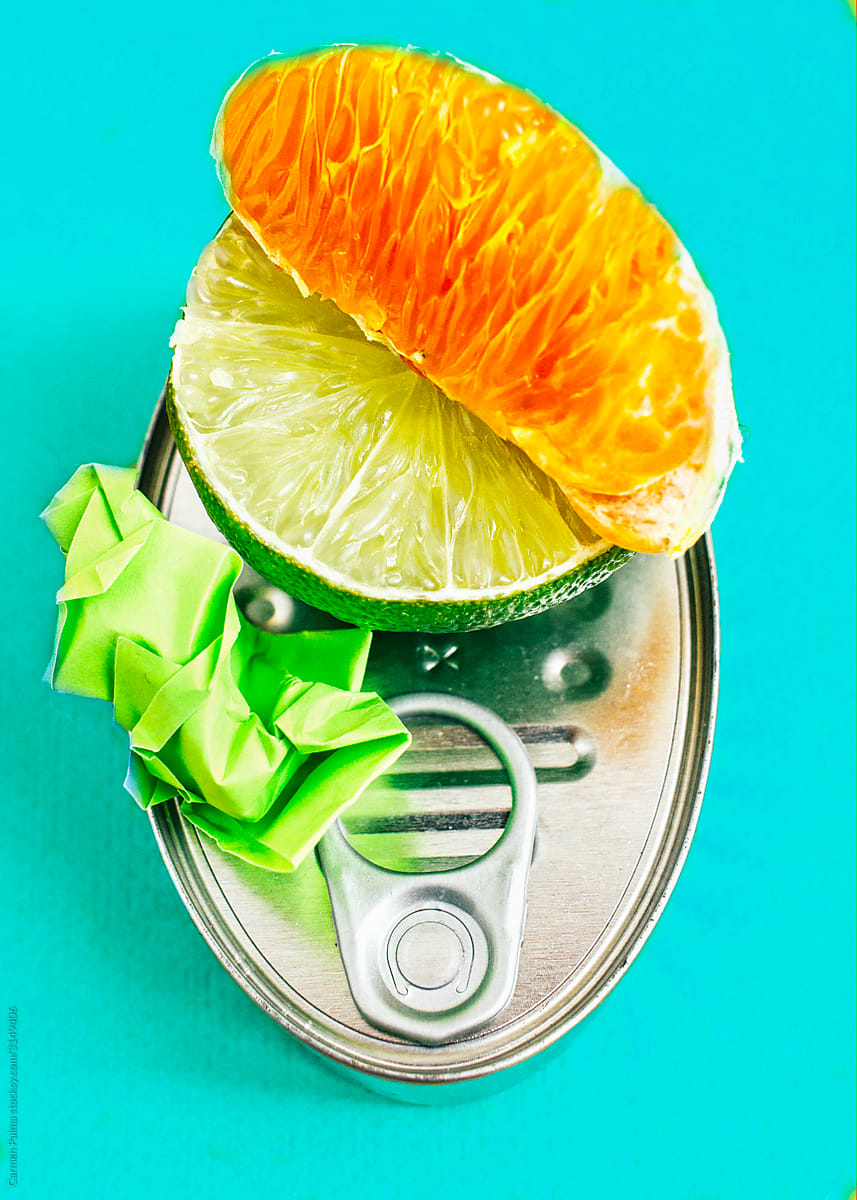 Abstract still life with a fish preserve can, fruit and a green piece of paper
