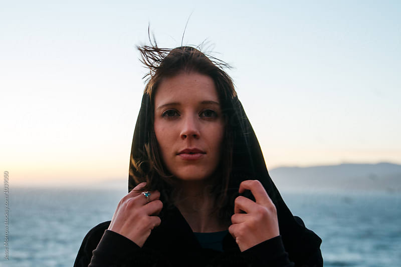 portrait of young female woman exploring coastal ocean adventure at sunset