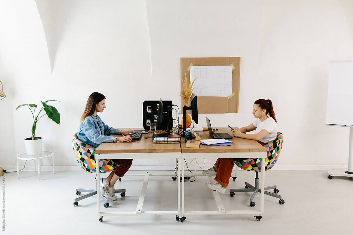 Two young female working together in office