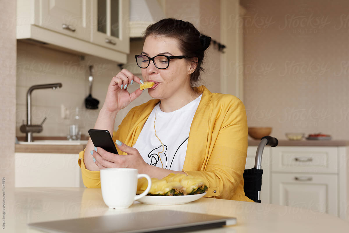 Disabled Woman With Smartphone Eating Pineapple