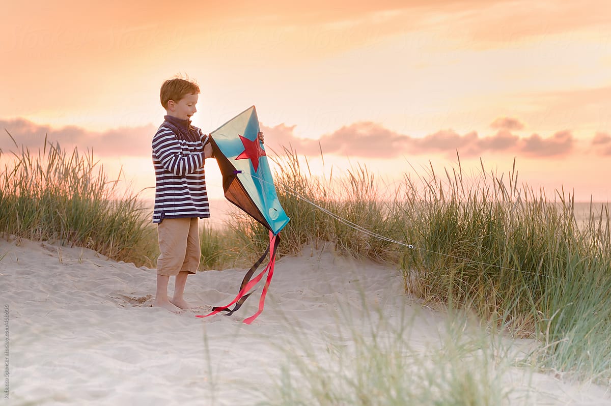 Child looks proudly at his kite
