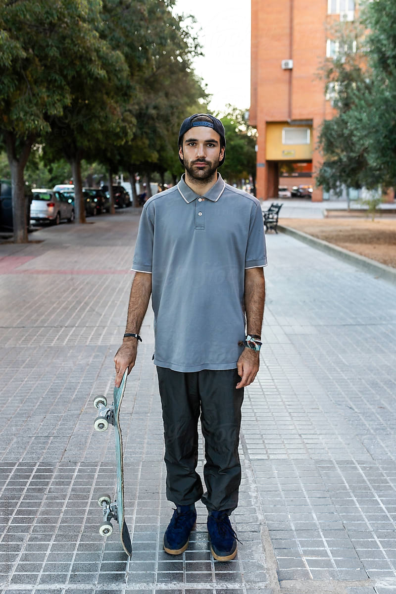 young man on  skateportrait of a young bearded man with a skateboard