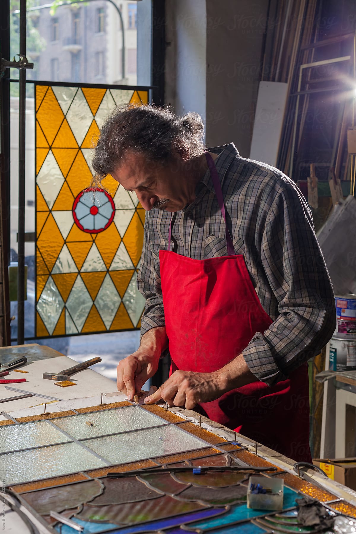 Artisan working on Stained Glass panels indoors