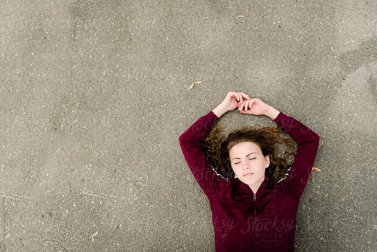 young woman on sidewalk with closed eyes