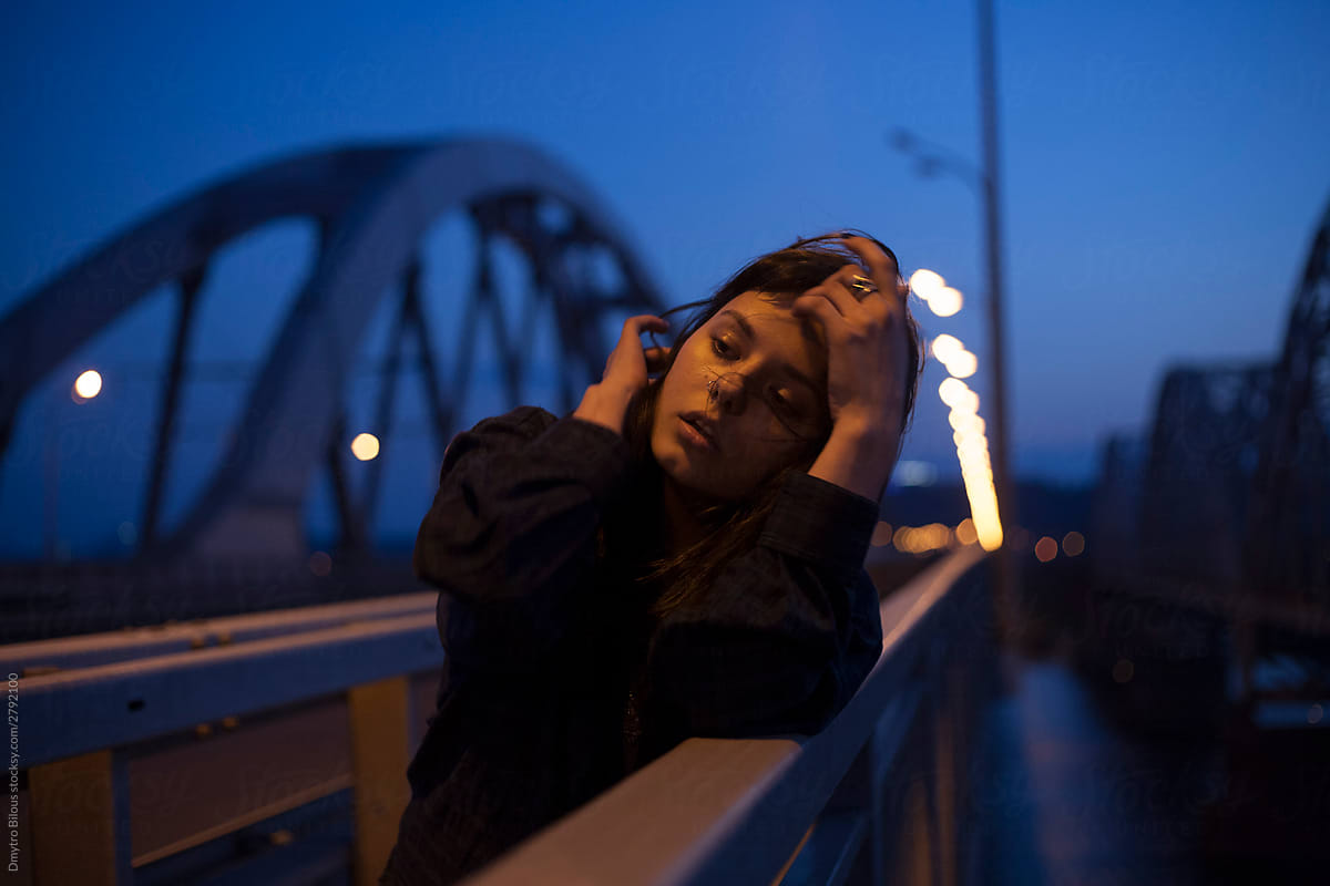 cinematic photo of a girl on a night bridge