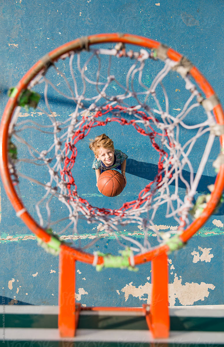 Young Child outside Looking Up at basketball hoop