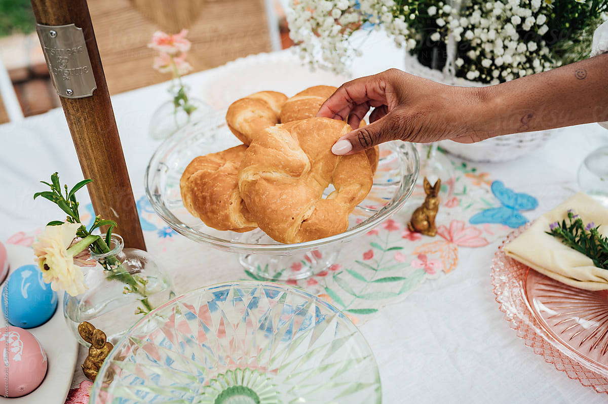 Woman grabbing croissant at the Easter table scape