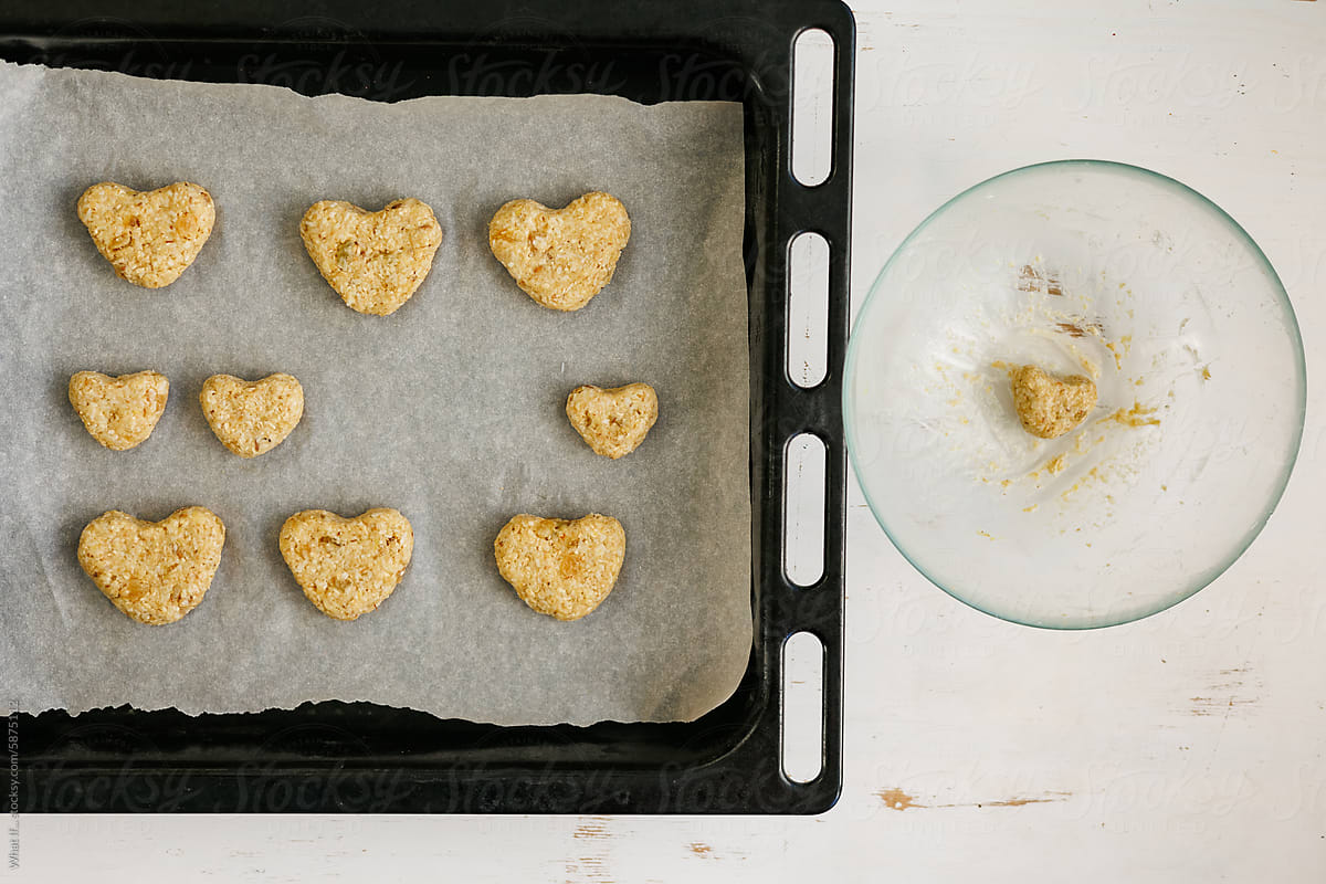 Homemade heart cookies on parchment before baking.