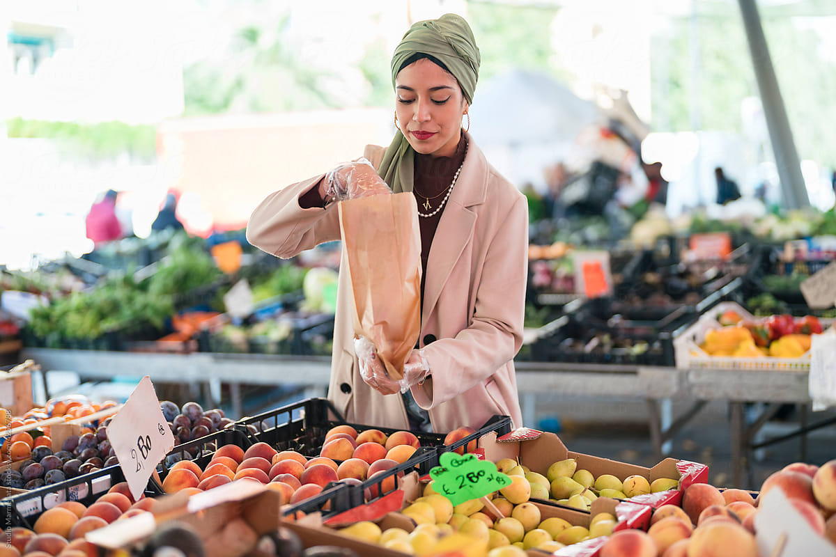 Muslim female packing fruits on market