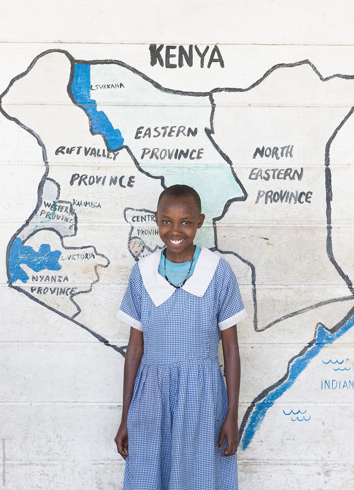 School girl standing in front of map of Kenya.