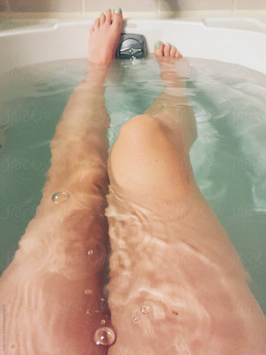 Woman\'s legs relaxing in a hot bath