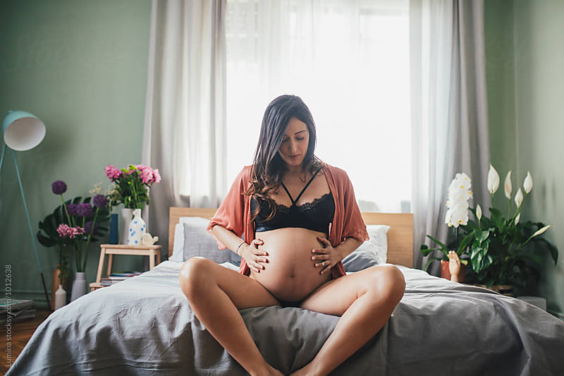 Pregnant Woman Sitting on the Bed in Her Bedroom