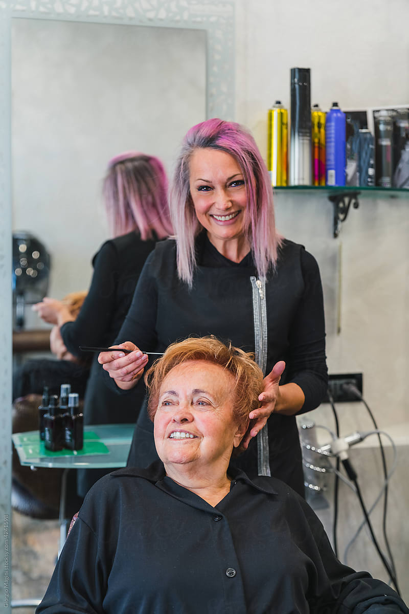 Smiling Hairdresser Combing a Senior Customer