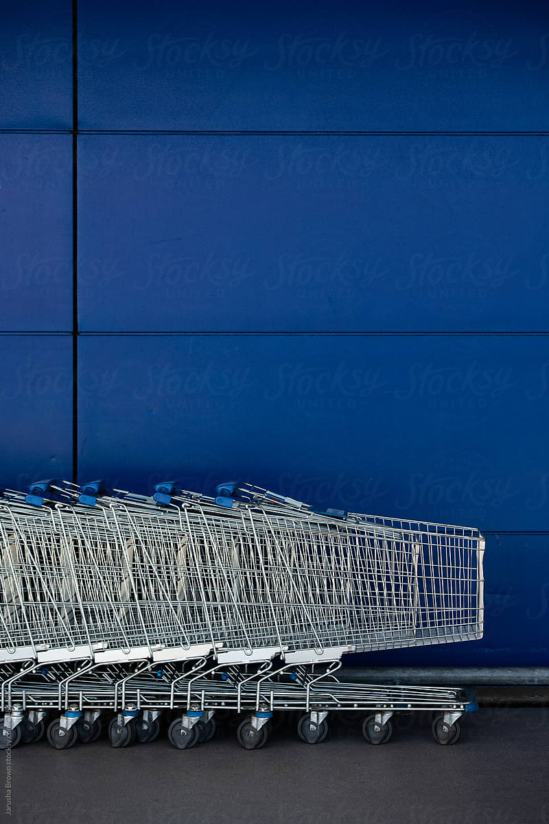 Shopping carts against a blue wall.