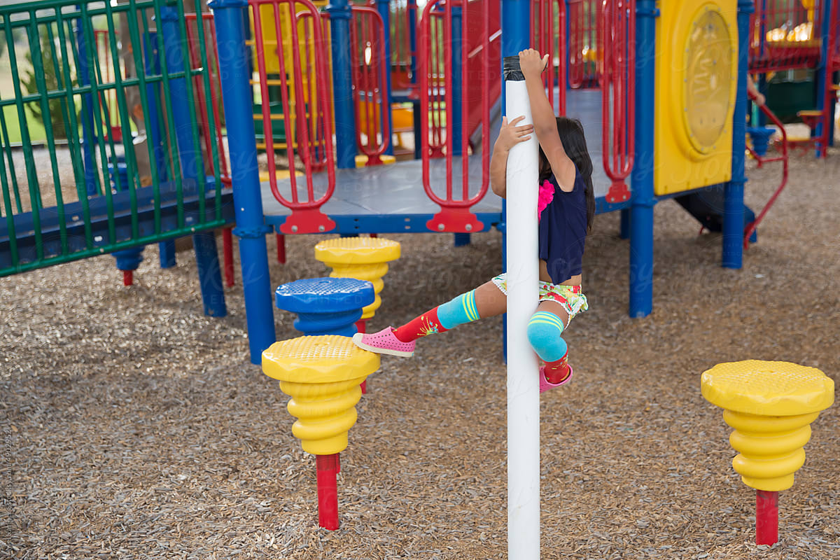 Girl in colorful knee socks climbing in park