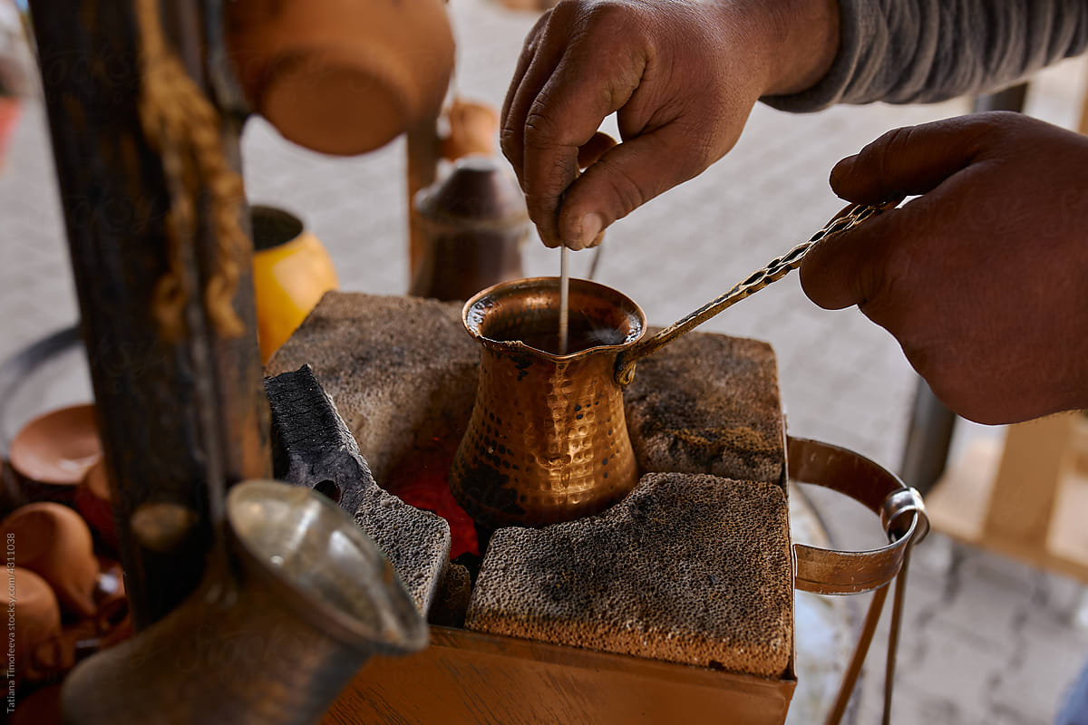 a man makes oriental coffee in a turk