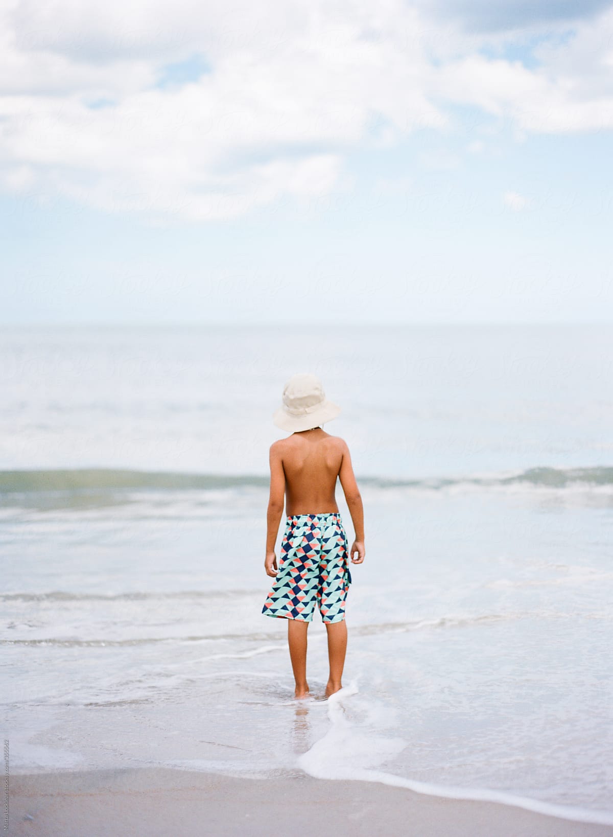 Boy At The Beach Wearing A Bucket Hat by Stocksy Contributor Marta  Locklear - Stocksy