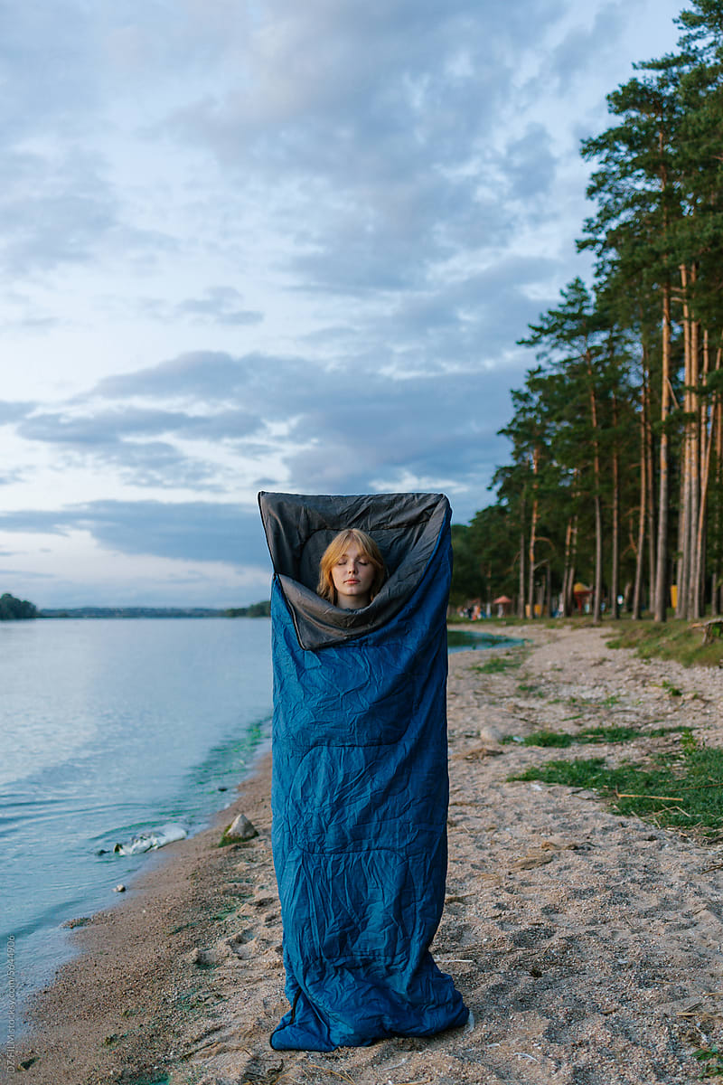 A woman in a sleeping bag outdoors