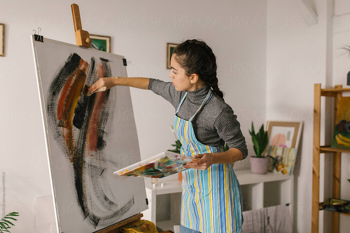 Painter in art studio painting on canvas