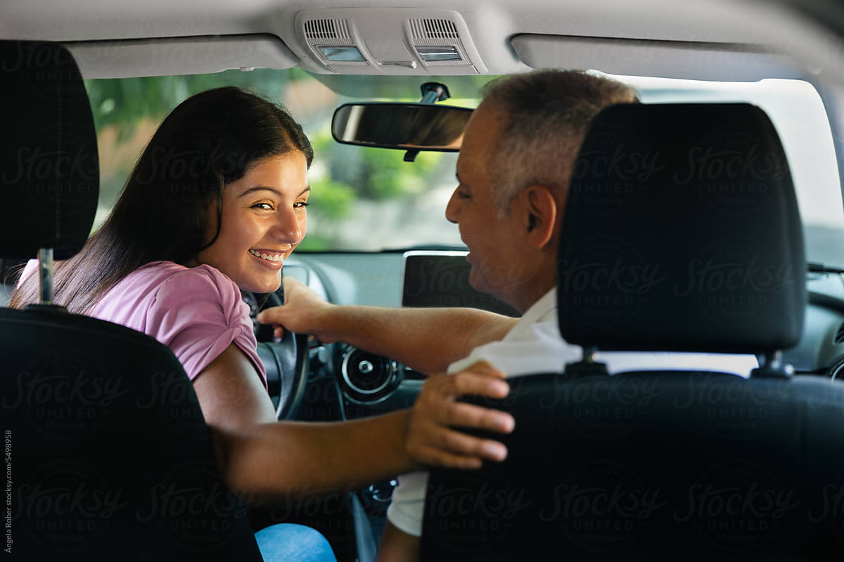 Smiling young woman reversing her car