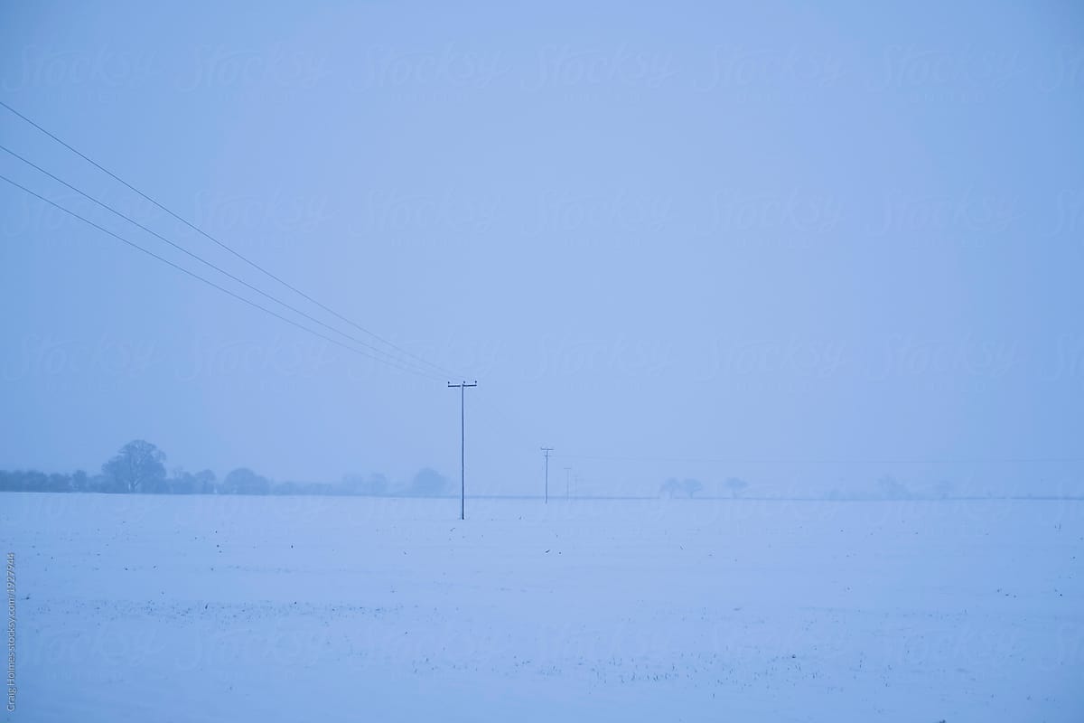 Snow scene with power cables passing accross a field