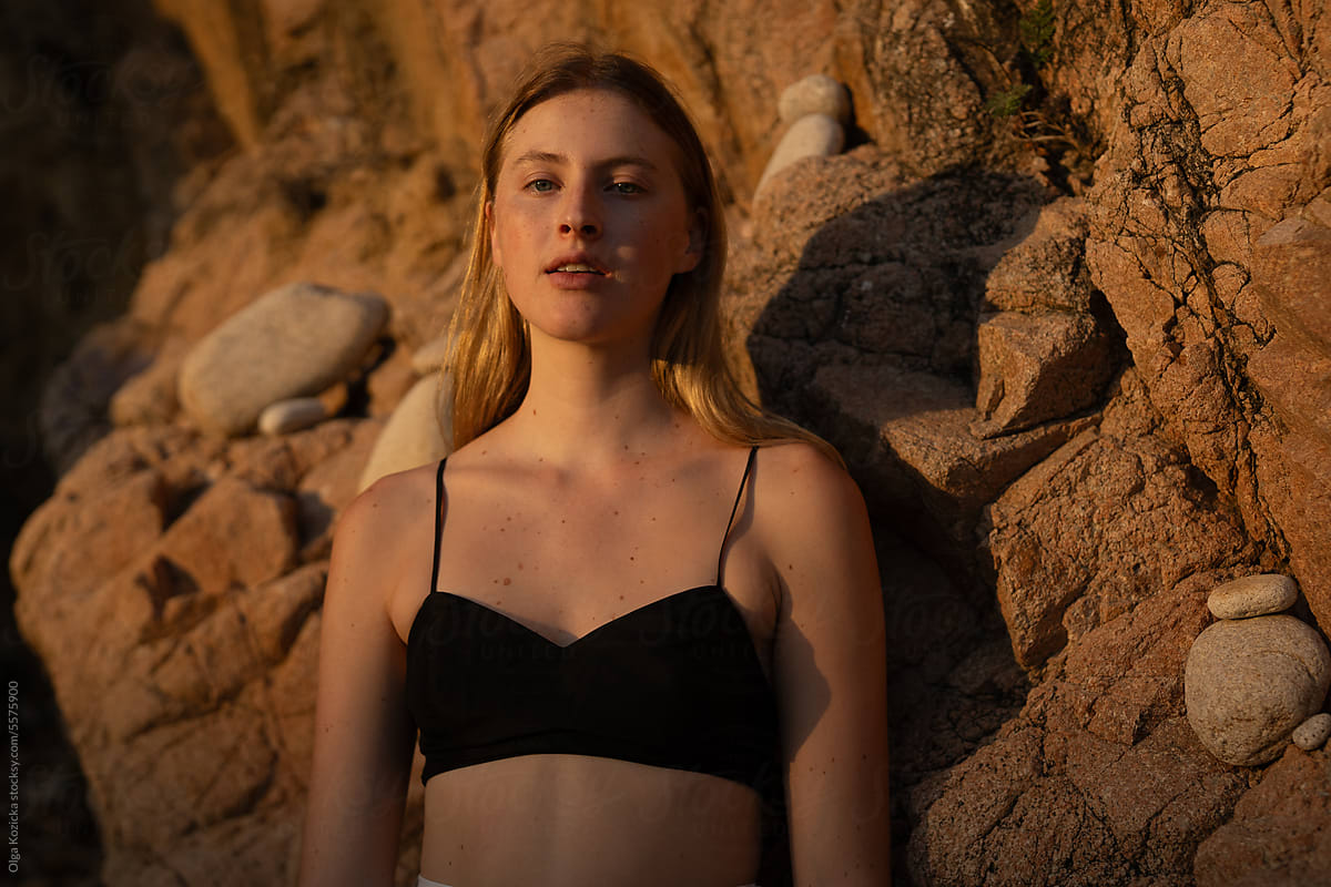 Blonde Woman On Rocky Background During Golden Hour