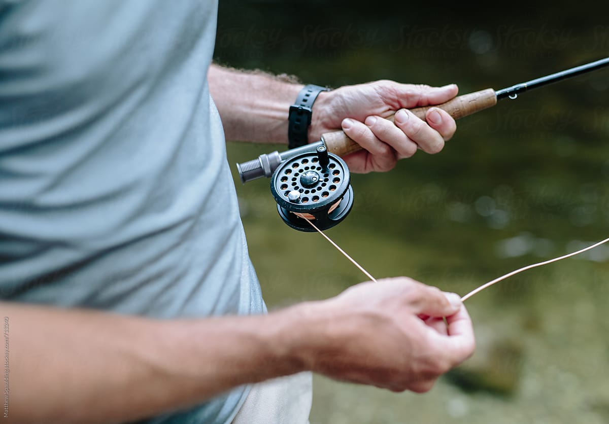 Close up of hands with fishing rod and line outdoors