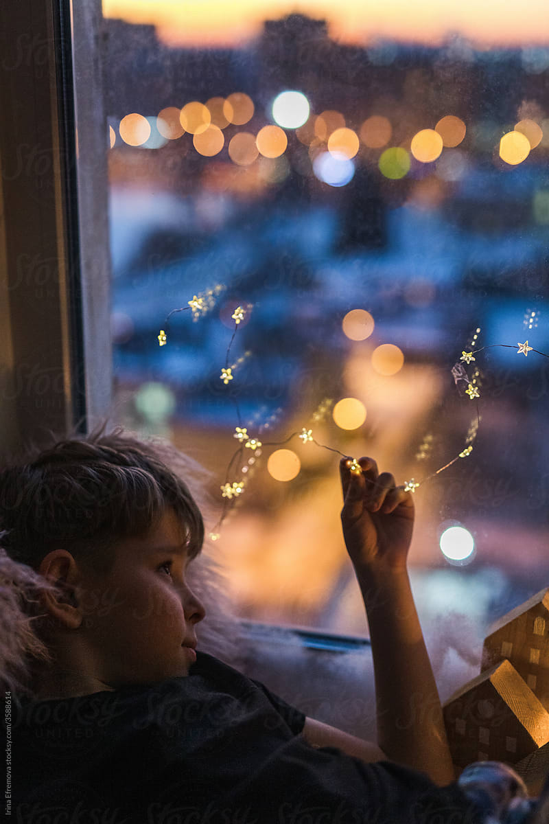 Boy on the window holding a star