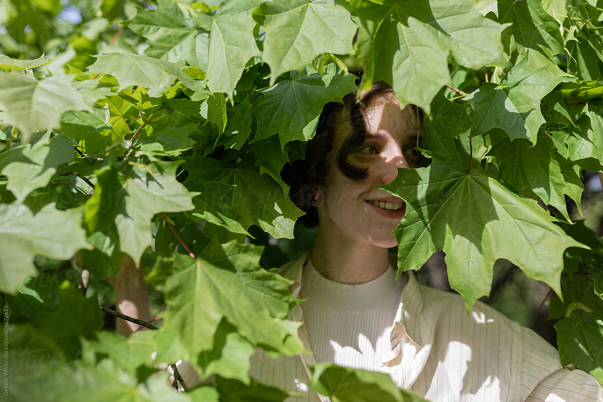 girl smiling in the leaves of a tree