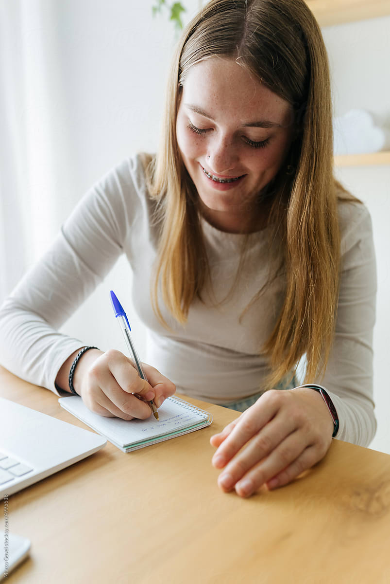 Young woman writing in notepad