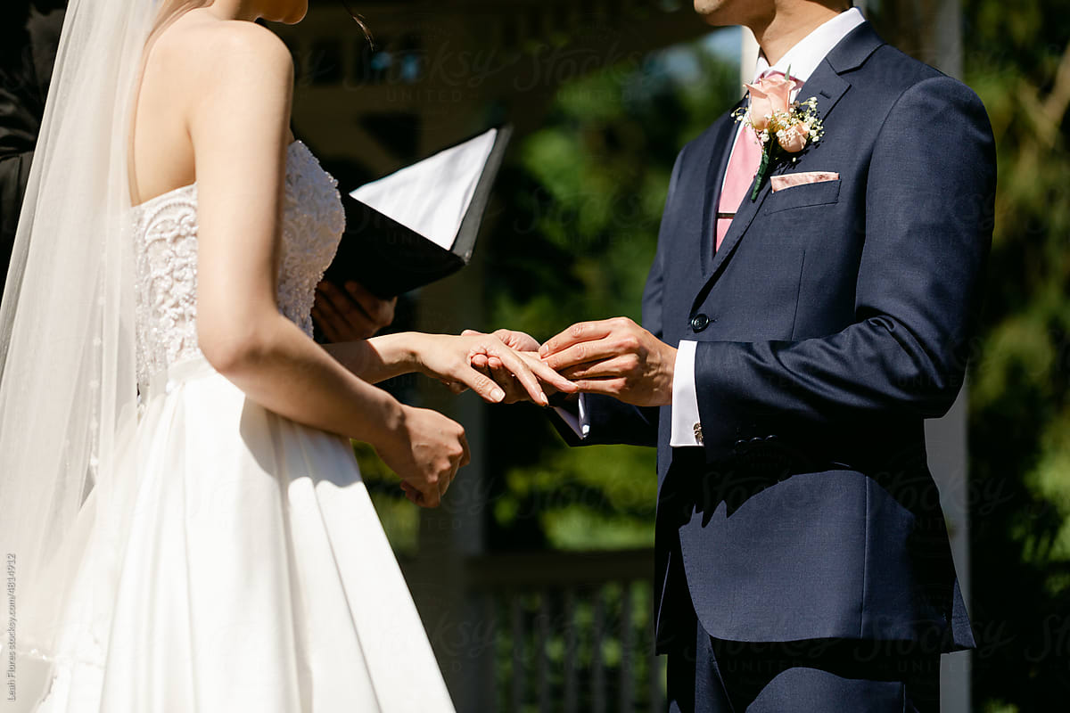 Groom Placing Ring on Bride\'s Finger