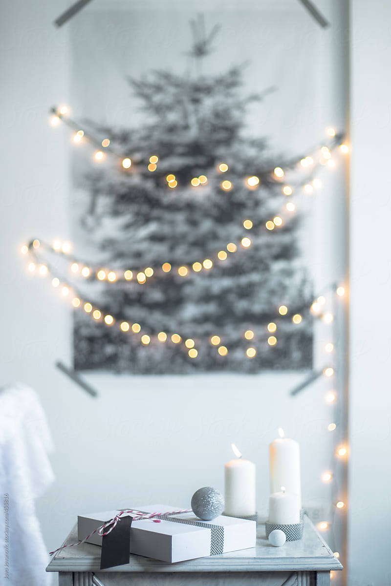 gift and candles in front of printed Christmas tree