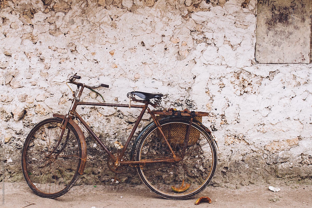 Bicycle leaning against the wall of a traditional African mud house.