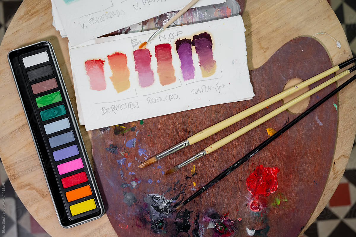 Painting supplies on wooden table in art studio