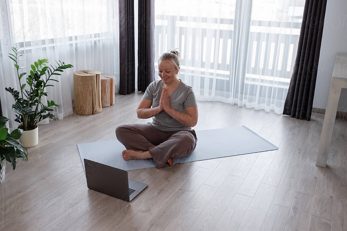 Woman greeting online instructor with namaste gesture