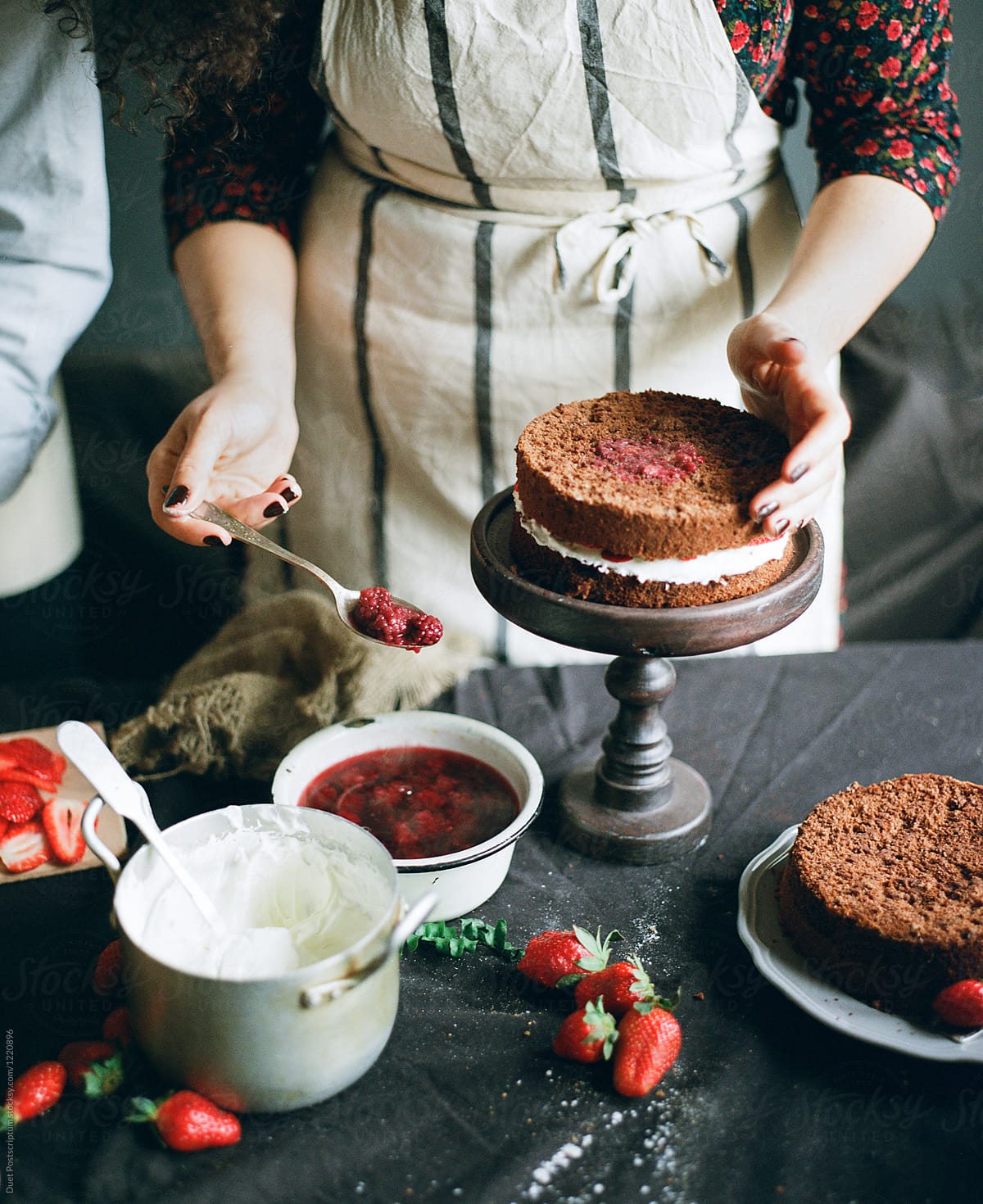 A cook puts berries into cake