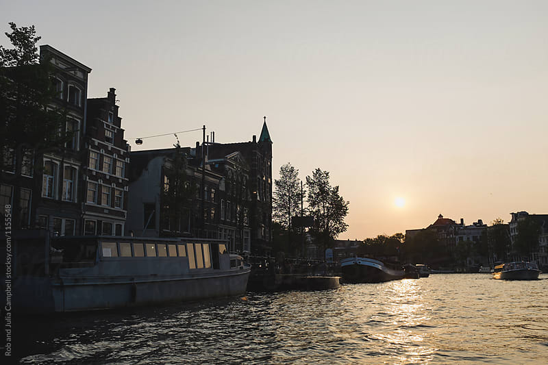 Sunset and house boats on canal in Amsterdam