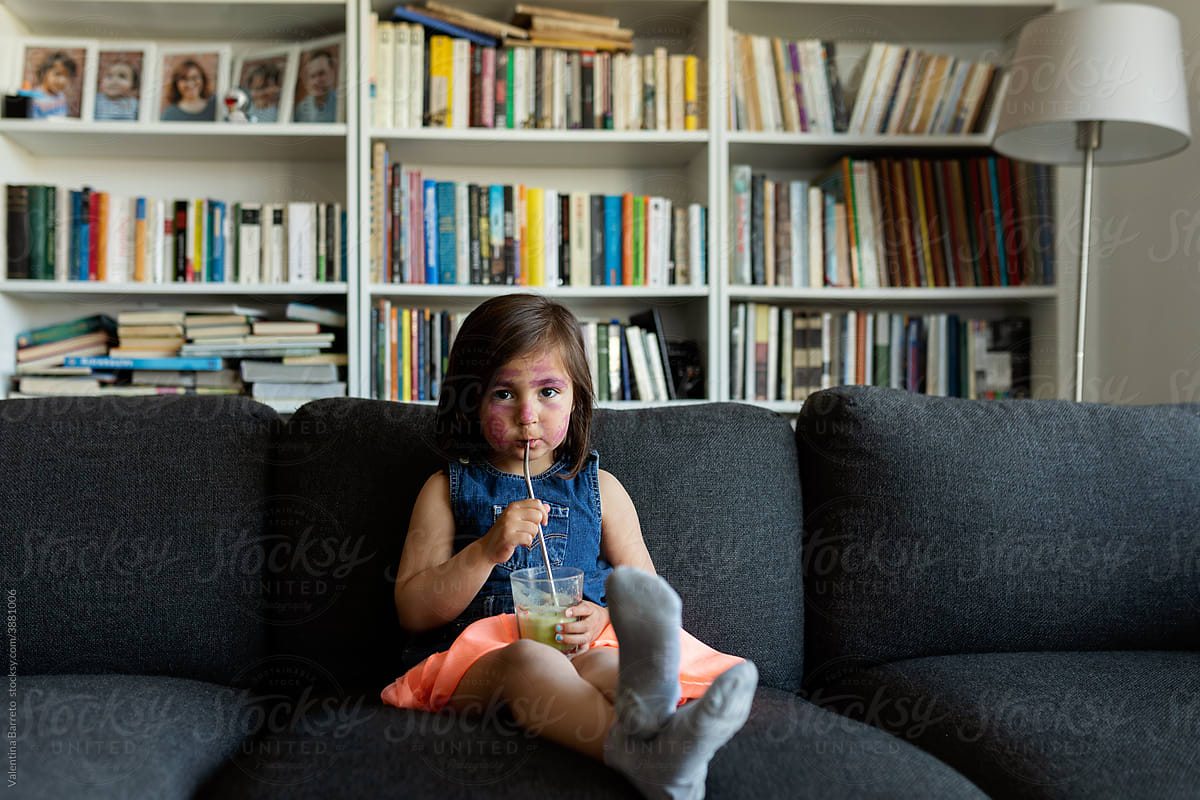 Little girl drinking a juice at home
