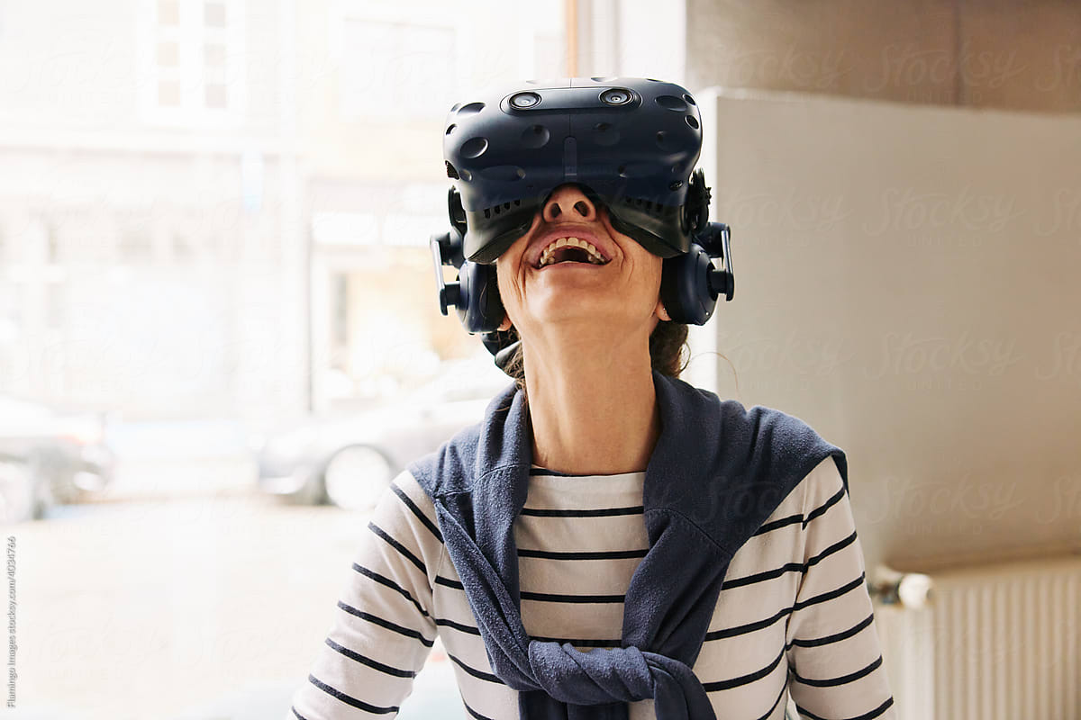 Senior woman laughing while wearing a vr headset