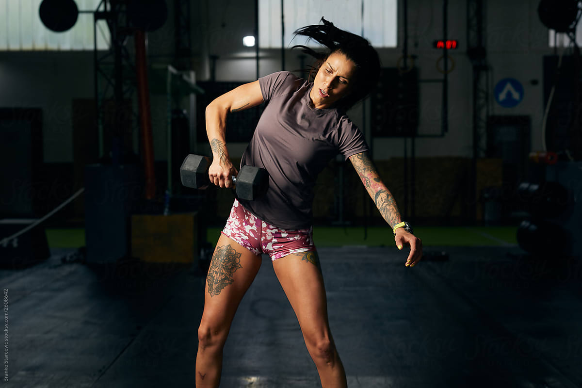 Athlete woman practicing with dumbbells.