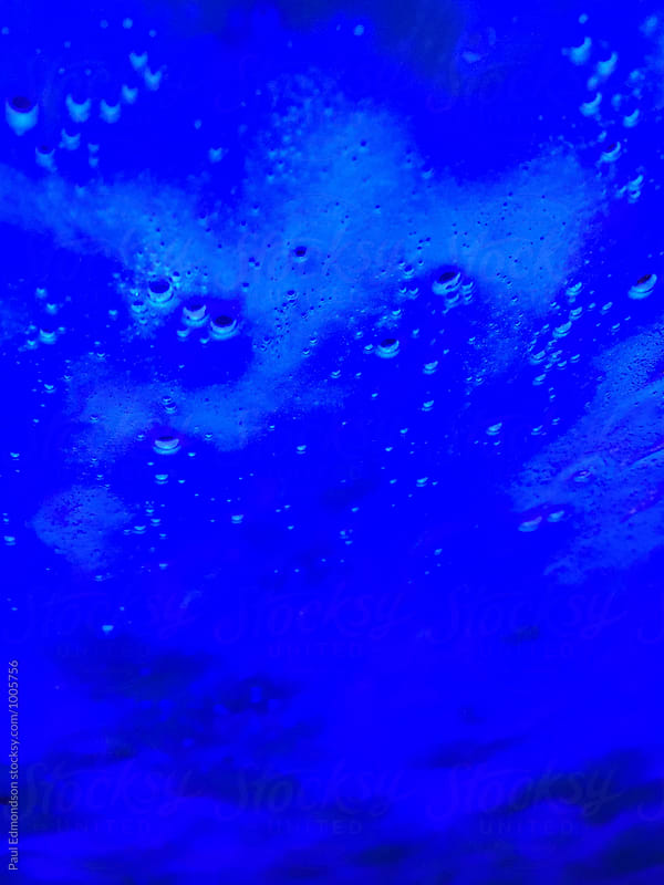 Close up of soapy water on car windshield with blue light