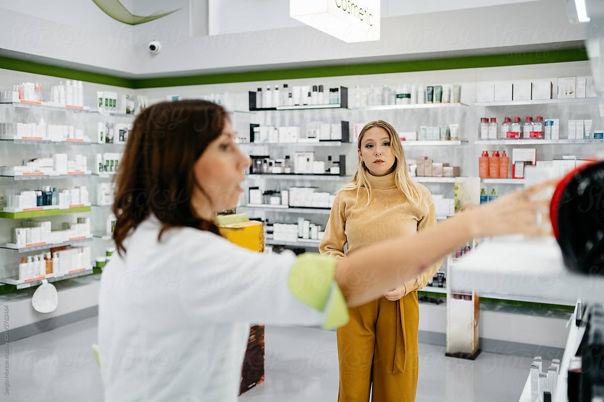 Pharmacist grabbing a medication to show to a customer