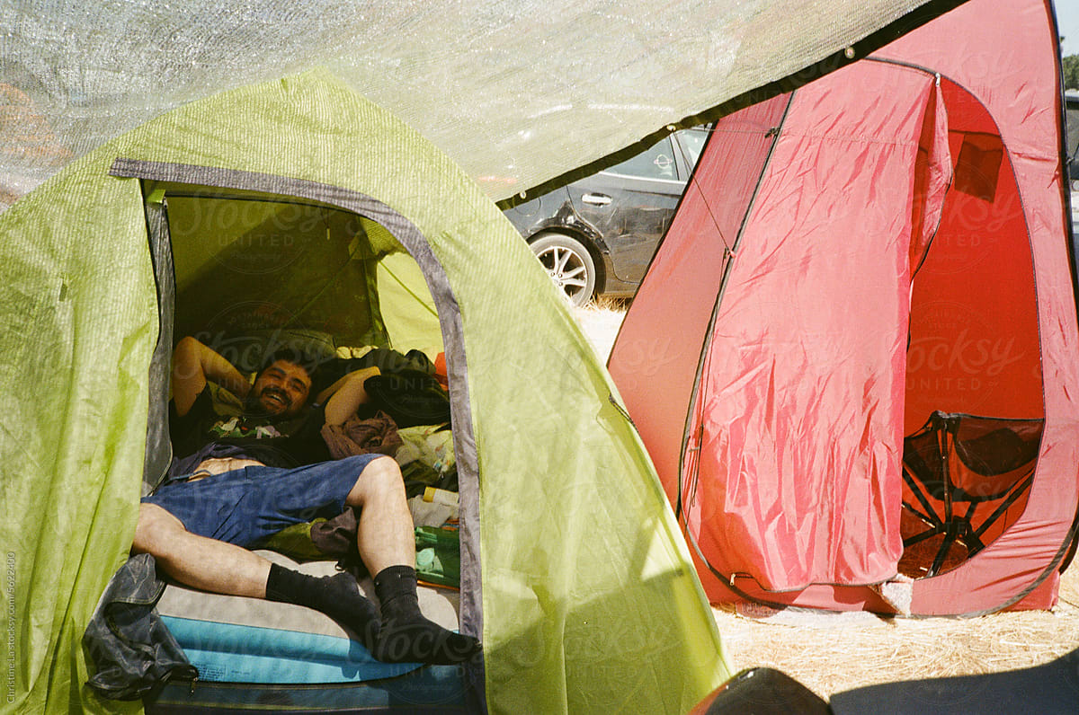 Man in tent camping at music festival shot on film.