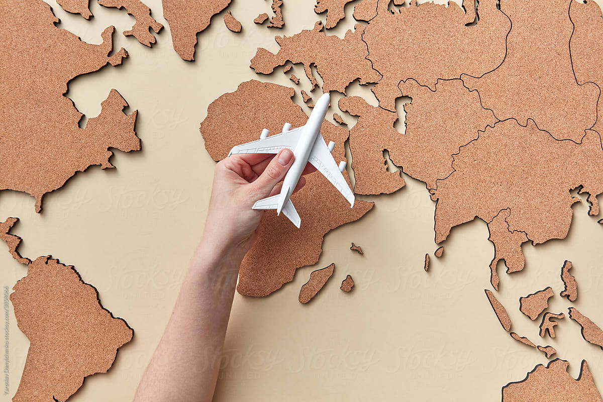 Woman holding plane model above map